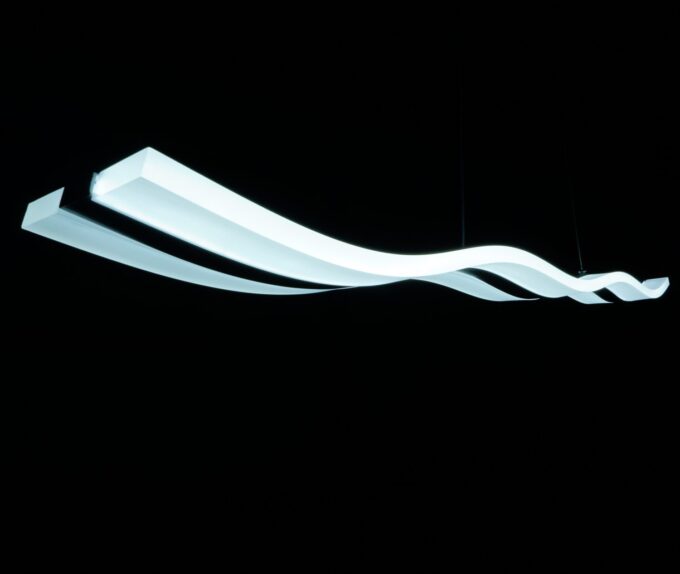 Modern wavy LED pendant light fixture against a black background.