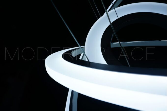Large modern chandelier with LED lights and crystal teardrop details, nestled in a coffered ceiling.