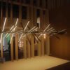 HTB1opVMJXXXXXbXapXXq6xXFXXXa Modern art installation featuring an array of "Piano" Pendant Light Fixtures intersecting at various angles in a dimly lit room with wooden elements in the background.