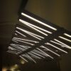 IMG_20171206_112453 Modern LED chandelier with linear lights in a dark room.