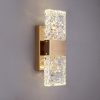 Modern gold wall sconce with illuminated textured glass shades
