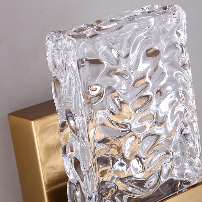 Textured glass vase with a gold accent on beige background.