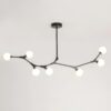 Modern branch-style chandelier with white globes on a gray background.