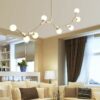 Modern living room with stylish spherical chandelier and cozy sofa.