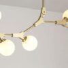 Modern gold chandelier with geometric design and spherical bulbs.