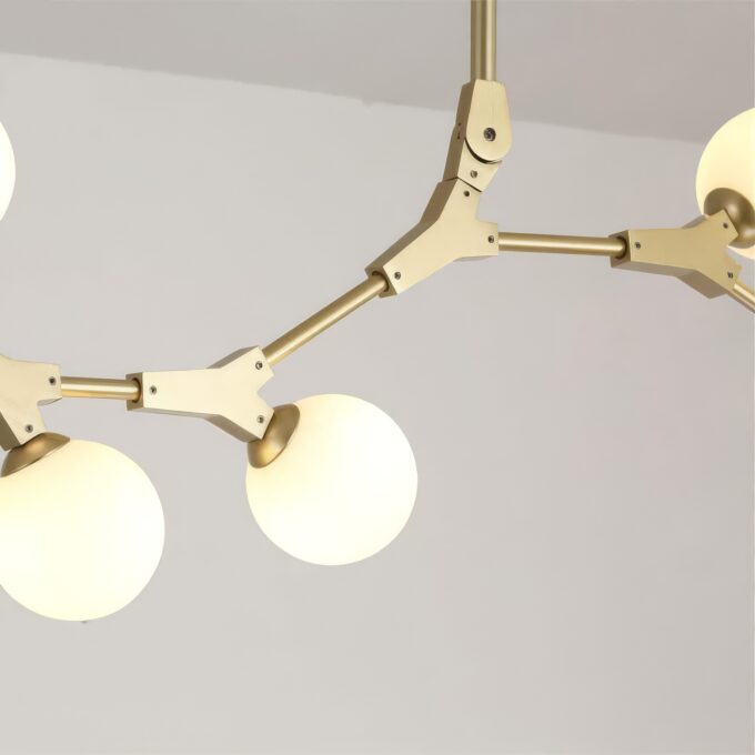 Modern gold chandelier with geometric design and spherical bulbs.