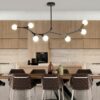 Modern kitchen interior with unique branch chandelier and bar stools.