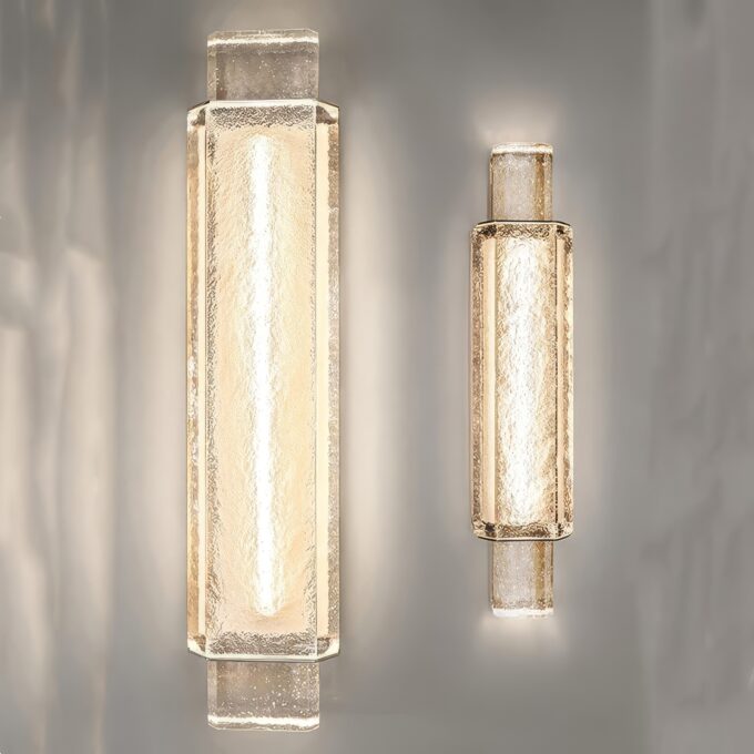 Two modern wall sconce lights illuminated on a gray background.