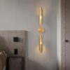 Modern gold wall sconce lighting in a contemporary bedroom setting.