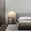 Drop-shapes-pendant-light-1 Modern bedroom with hanging pendant light, side table, and gray bed.