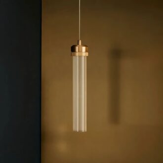 Modern cylindrical pendant light hanging against a dark backdrop.
