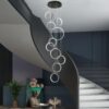 Modern spiral staircase with artistic chandelier, elegant decor, and contemporary art in a stylish interior setting.