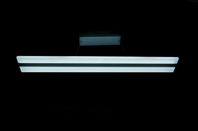DSC00307 Modern fluorescent ceiling light fixture suspended in a dark room.
