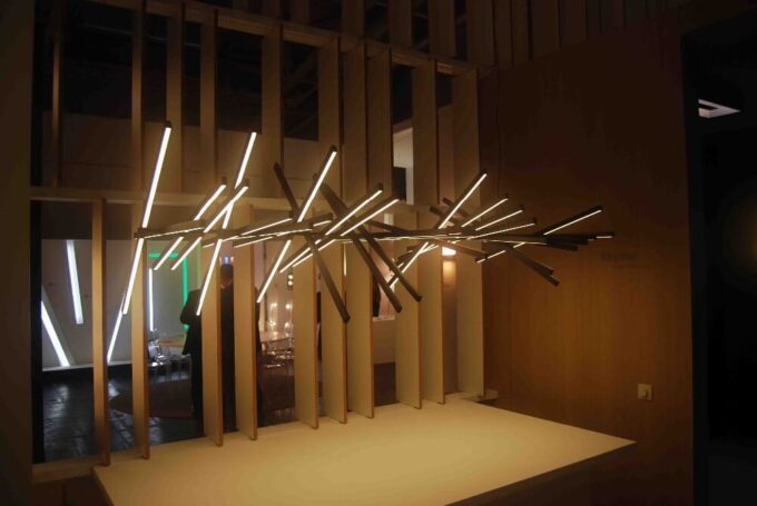 HTB1opVMJXXXXXbXapXXq6xXFXXXa Modern art installation featuring an array of "Piano" Pendant Light Fixtures intersecting at various angles in a dimly lit room with wooden elements in the background.