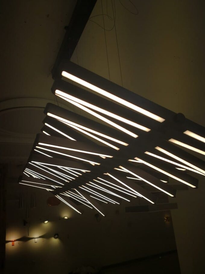 IMG_20171206_112453 Modern LED chandelier with linear lights in a dark room.