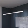 silver-led-pendant-linear-fixture Modern kitchen with sleek LED pendant light over marble countertop.