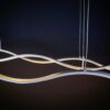 DSC01035 Modern wave-shaped LED pendant light hanging against a dark background.