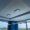 image0 Modern office ceiling with stylish pendant lights and city view through windows.
