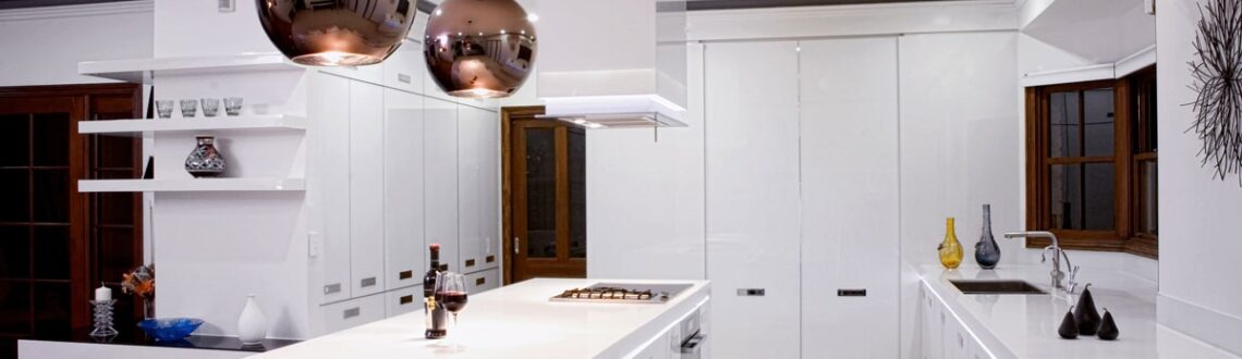 Contemporary kitchen with sleek white cabinets, stainless steel appliances and warm lighting