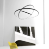 Modern pendant light fixture above yellow chair and abstract artwork in minimalist room.