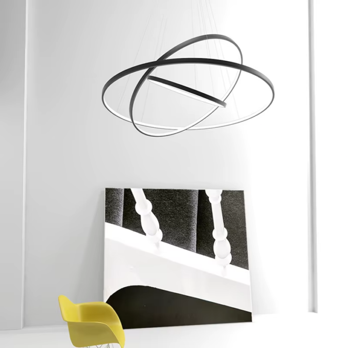 Modern pendant light fixture above yellow chair and abstract artwork in minimalist room.