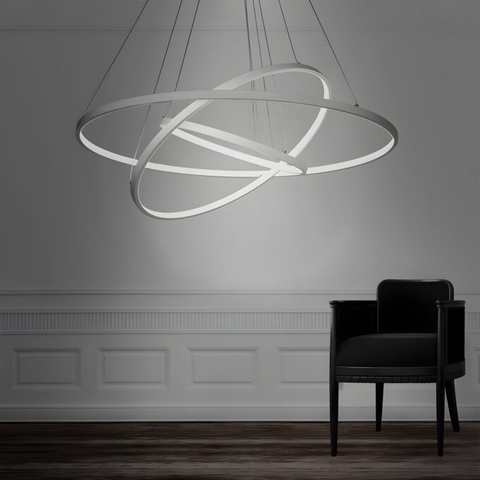 Modern circular LED pendant light above a black chair in an elegant room.