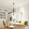 dinning-table-mini-pendant-white-black Modern kitchen diner with colorful wall art, pendant lights, and dining table setup.