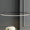 matte-black-jonathan-y-pendant-lights-jyl7220a-64_1000 (Custom) Modern circular LED pendant light fixture in a minimalistic interior with a flower arrangement beneath it.
