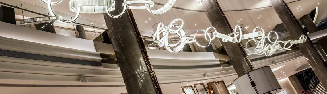 Modern chandelier with looping design in a luxury hotel lobby.