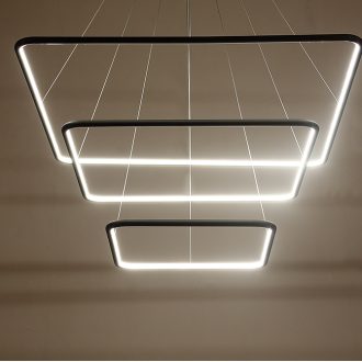 Modern LED pendant lights in geometric shapes hanging from ceiling.
