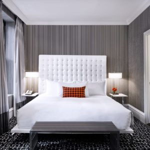 modern hotel guest room in gray with dual lamps