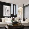 Modern living room with white sofas, pendant lights, and monochrome wall art.