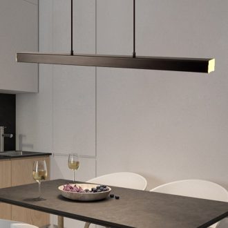 Modern pendant light over minimalist dining table with wine glasses.