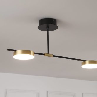 Modern black and gold ceiling light fixture in a white room.