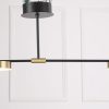 MC1541R-2 (4) Modern black and brass pendant light fixture against a white panelled wall.