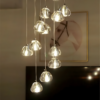 1 Modern chandelier with multiple hanging glass lights, elegantly illuminating a room with a framed abstract art piece in the background.