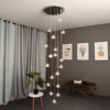 2 Modern living room with chandelier lighting, grey curtains, plant on white side table, and framed art on grey walls.