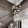 3 Modern staircase with a sleek chandelier, dark textured walls, and contemporary decor featuring artwork and flowers in a stylish home.