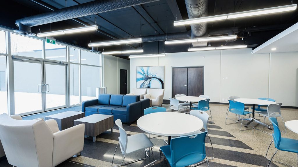 White office with blue furniture and suspended office fixtures