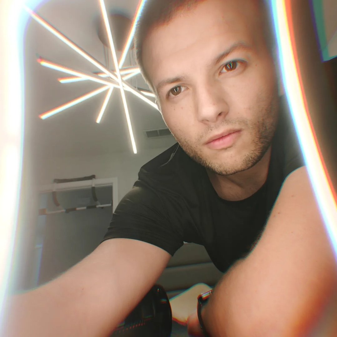 Man in black shirt with lens flare effect and starburst light.