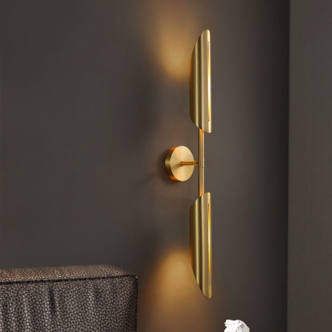 5 Modern gold wall sconce lighting fixture against dark wall.