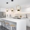 51l7EmyVLvL._AC_SL1000_ Modern white kitchen interior with gold pendant lights and bar stools.