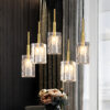 Elegant pendant lights with golden rods against a striped wall, bouquet below.