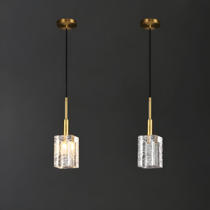 Elegant gold pendant lights with textured glass shades against a dark background.