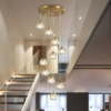 2 Elegant modern gold pendant light fixture with glass bulbs illuminating a chic, open-concept living space.