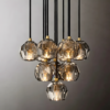 small (2) Modern geometric crystal pendant chandelier with warm lighting, black and gold accents, against a neutral background.